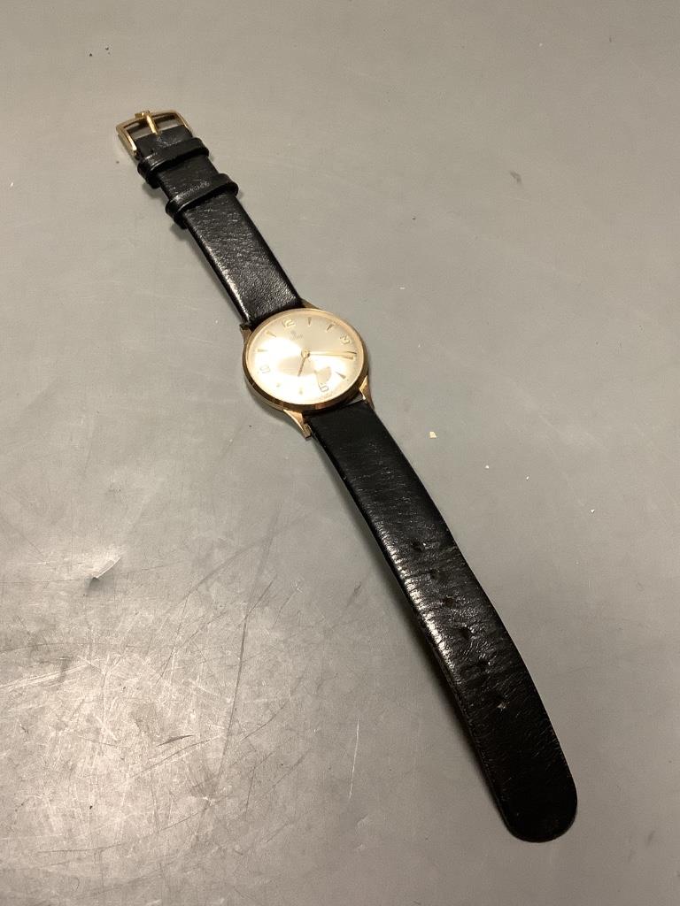 A gentleman's 1960's 9ct gold Tudor manual wind wrist watch, on a leather strap (lacking winding crown), with case back inscription, together with a Victorian gilt metal, amethyst and seed pearl brooch, 22mm.